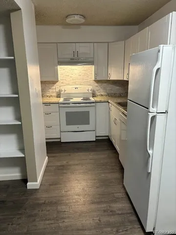 a kitchen with granite countertop cabinets stainless steel appliances a sink and a window