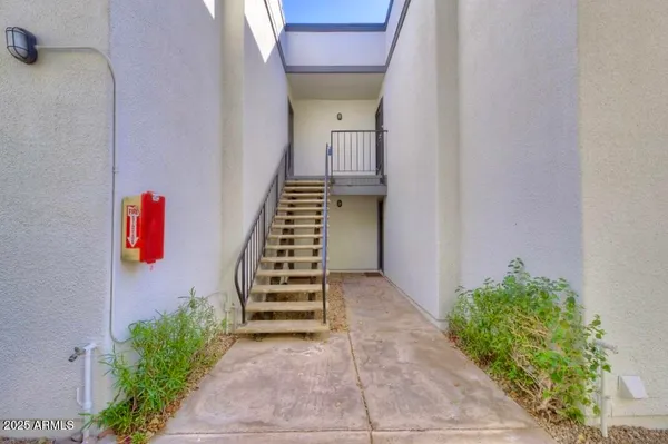 a view of a hallway with stairs and wooden floor