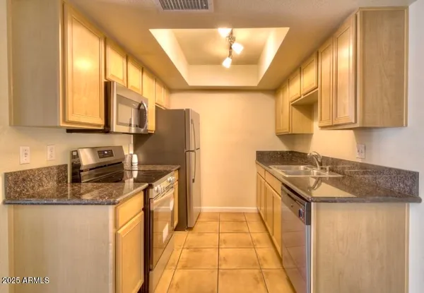 a kitchen with stainless steel appliances granite countertop a stove a sink and a refrigerator