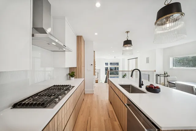 a kitchen with stainless steel appliances a sink a stove and a wooden floors
