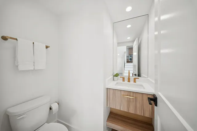 a bathroom with a sink vanity granite and toilet