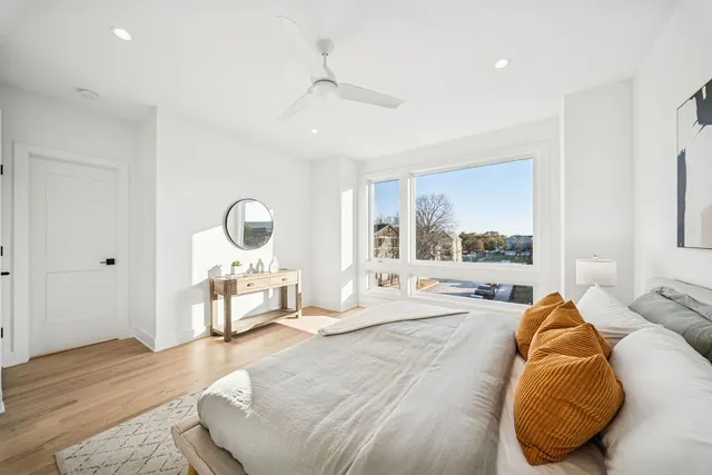 a large bedroom with a bed and a large window