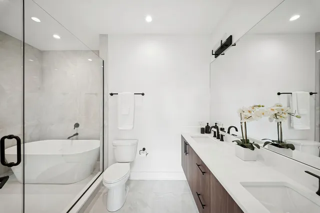 a bathroom with a double vanity sink toilet and shower