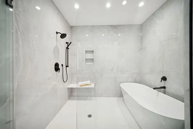 a bathroom with a tub a toilet and a shower