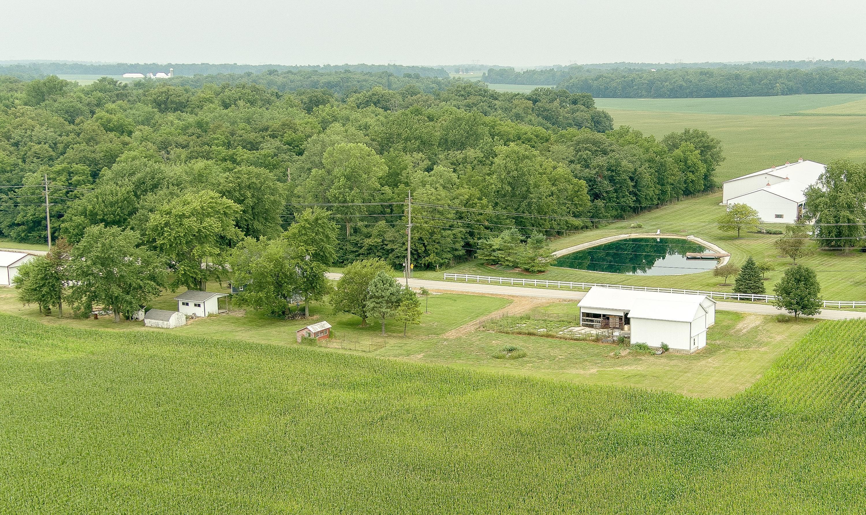 19834 Botkins Road Jackson Center, OH 45334 - Photo 27 of 32 Expansive agricultural property featuring a sizable pond, multiple outbuildings, and cultivated fields
