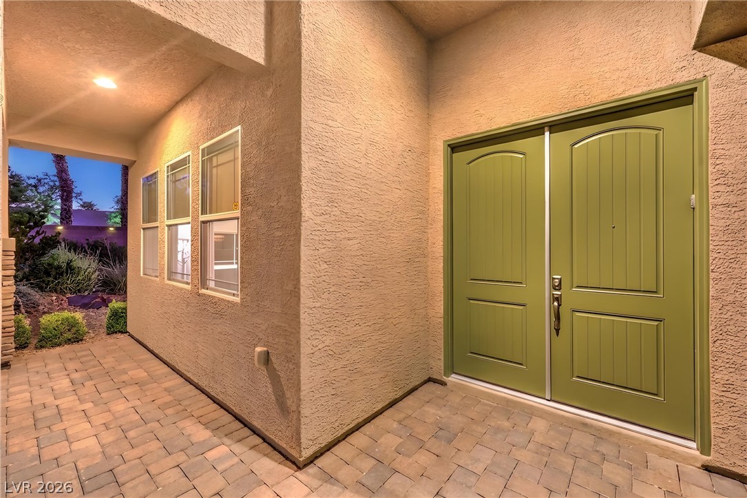 7119 Arabian Ridge Street Las Vegas, NV 89131 - Photo 7 of 73 Enter through robust double doors to a charming, illuminated patio with pavers.