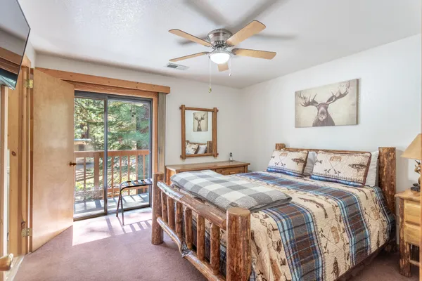 a bed sitting in a spacious bedroom next to a window