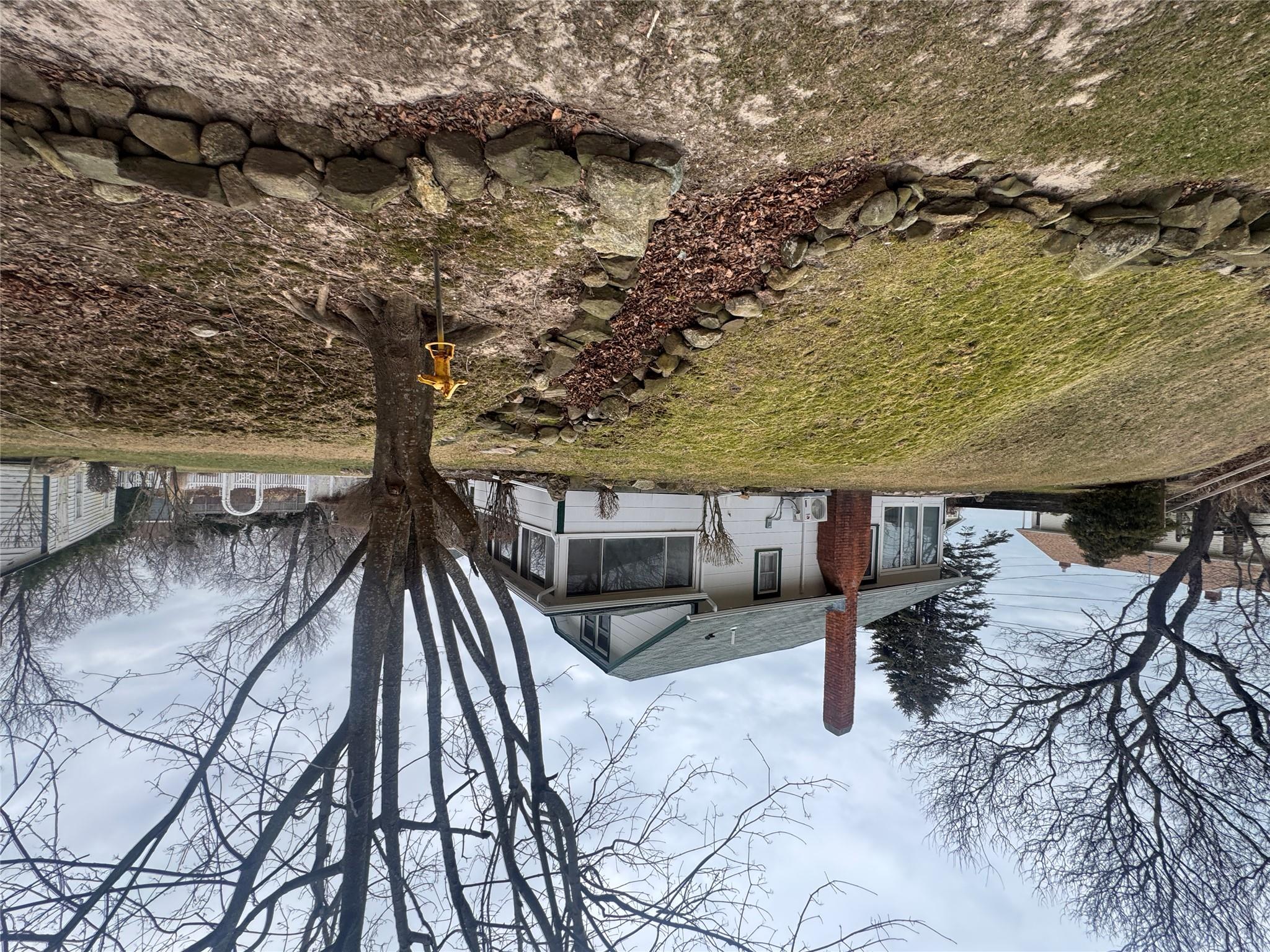 View of front of property featuring a sunroom and a front yard
