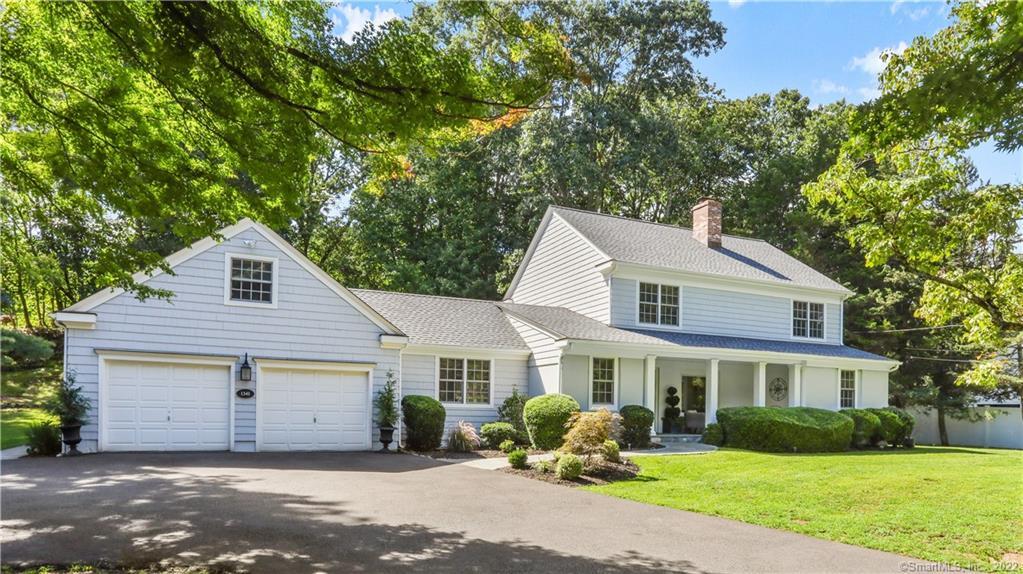 1341 Bronson Road Fairfield, CT 06824 - Photo 1 of 1 a front view of a house with a garden and trees