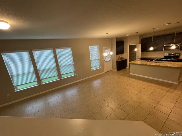 a view of a kitchen with furniture and a refrigerator