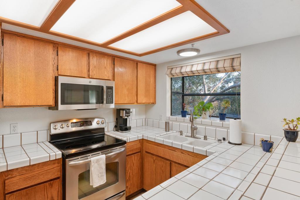 4055 Eagle Street, Unit 102 San Diego, CA 92103 - Photo 12 of 37 a kitchen that has a sink and a stove