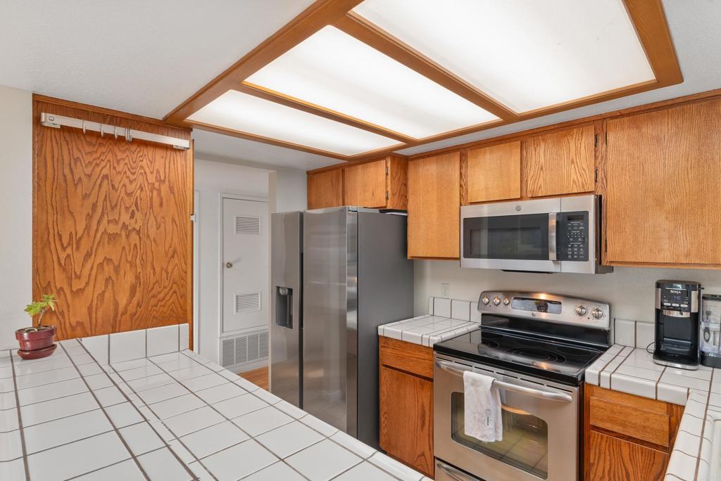 4055 Eagle Street, Unit 102 San Diego, CA 92103 - Photo 13 of 37 a kitchen with stainless steel appliances granite countertop a refrigerator and a stove