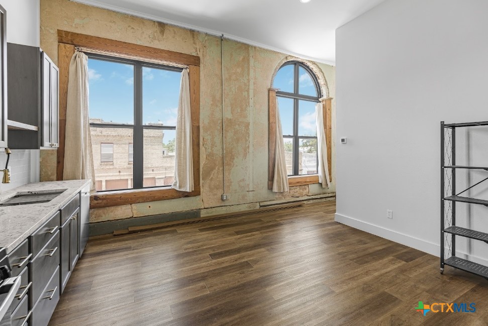 123 West May Street, Unit 1 Yoakum, TX 77995 - Photo 1 of 21 an empty room with wooden floor and windows