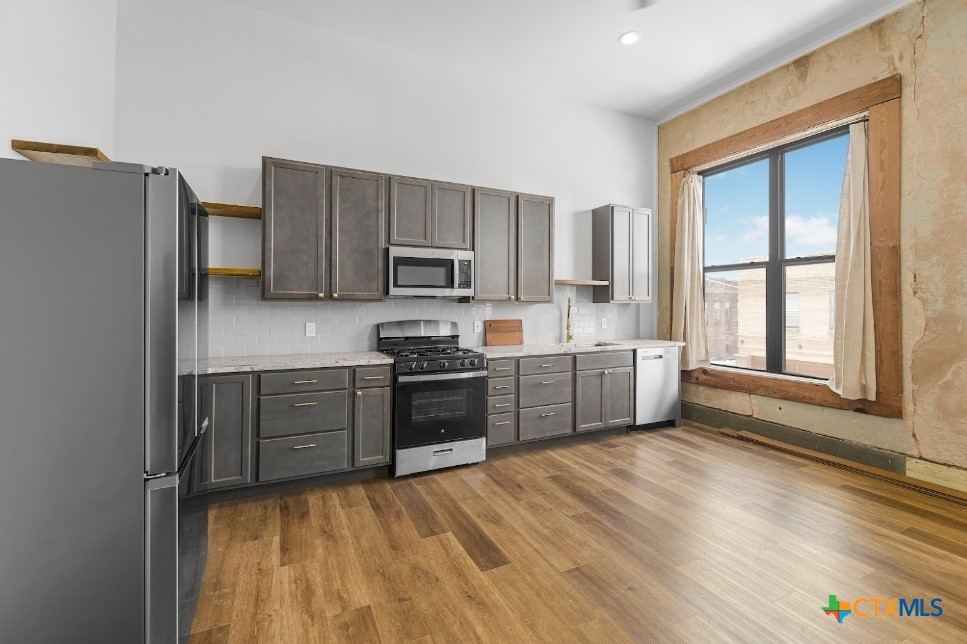 123 West May Street, Unit 1 Yoakum, TX 77995 - Photo 12 of 21 a kitchen with a refrigerator cabinets and wooden floor