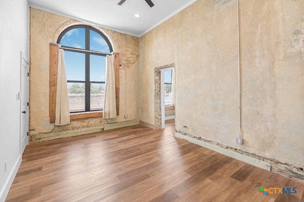 123 West May Street, Unit 1 Yoakum, TX 77995 - Photo 16 of 21 an empty room with wooden floor and windows