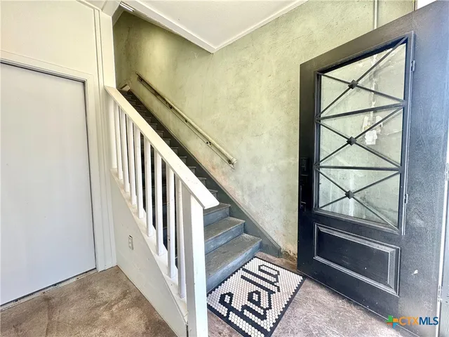 a view of a door with wooden floor and a bathroom