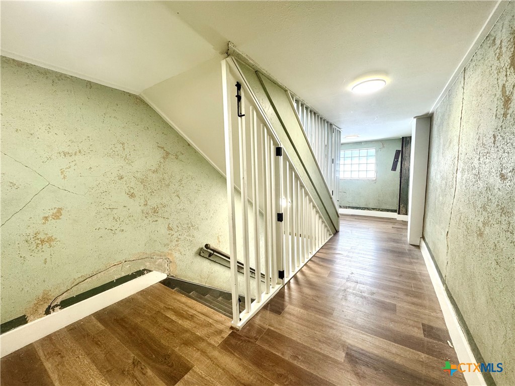 123 West May Street, Unit 1 Yoakum, TX 77995 - Photo 5 of 21 a view of a hallway with wooden floor and staircase
