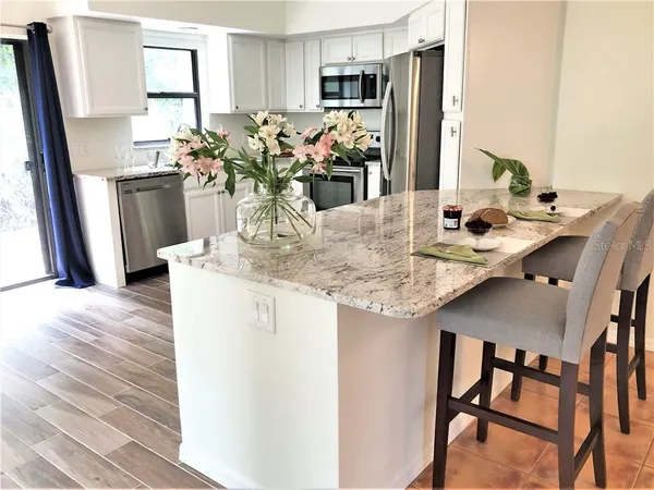 a kitchen with cabinets and wooden floor