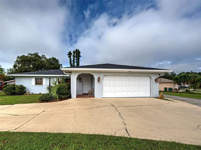 a view of a house with a yard and potted plants