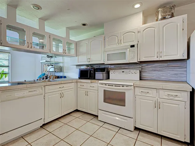 a kitchen with white cabinets stainless steel appliances and sink