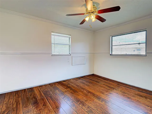 a view of empty room with wooden floor