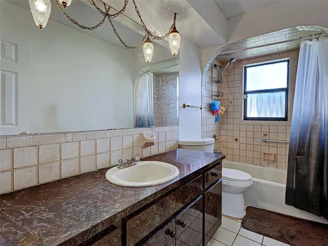 a bathroom with a granite countertop sink a toilet and mirror
