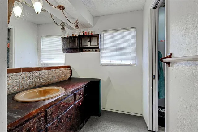 a kitchen with stainless steel appliances a sink a stove a microwave a refrigerator and cabinets