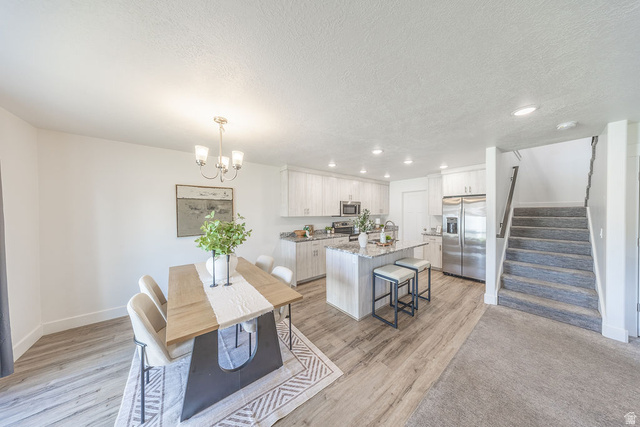 4991 South 475 West Washington Terrace, UT 84405 - Photo 14 of 31 Open-concept living space featuring a dining area, kitchen, and staircase.