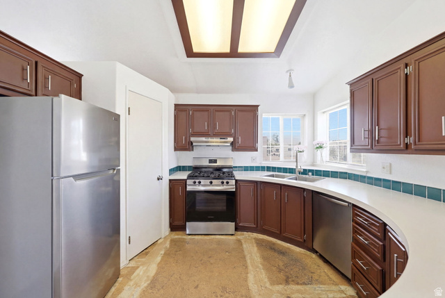 2491 Highway 89, Unit 614 Pleasant View, UT 84404 - Photo 8 of 27 Kitchen featuring dark wood cabinetry, white countertops, stainless steel appliances, a gas range with an overhead hood, and a dual basin sink beneath a window