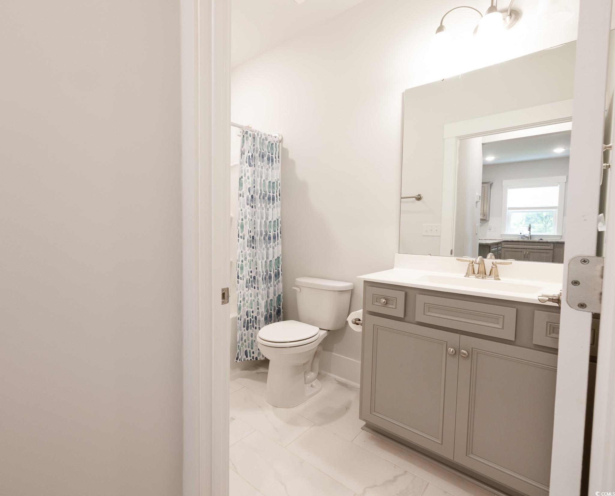 6081 Tramonto Street Myrtle Beach, SC 29577 - Photo 12 of 18 Full bathroom featuring vanity, marble look tiles, and a shower with shower curtain