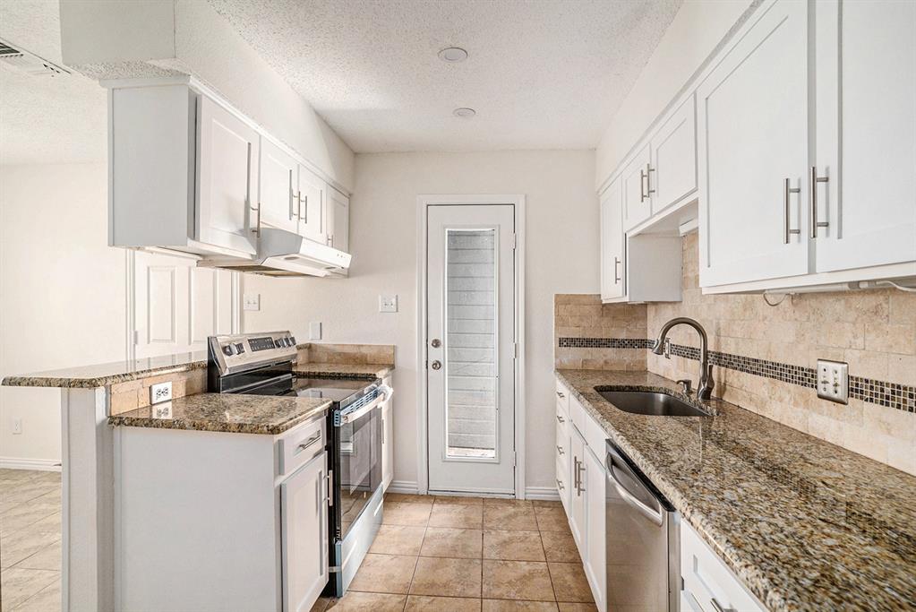 602 McAnear Street Cleburne, TX 76033 - Photo 11 of 27 a kitchen with stainless steel appliances granite countertop a sink stove and refrigerator