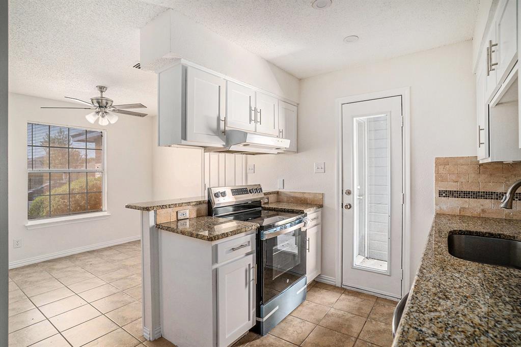 602 McAnear Street Cleburne, TX 76033 - Photo 13 of 27 a kitchen with stainless steel appliances granite countertop a stove a sink and a refrigerator