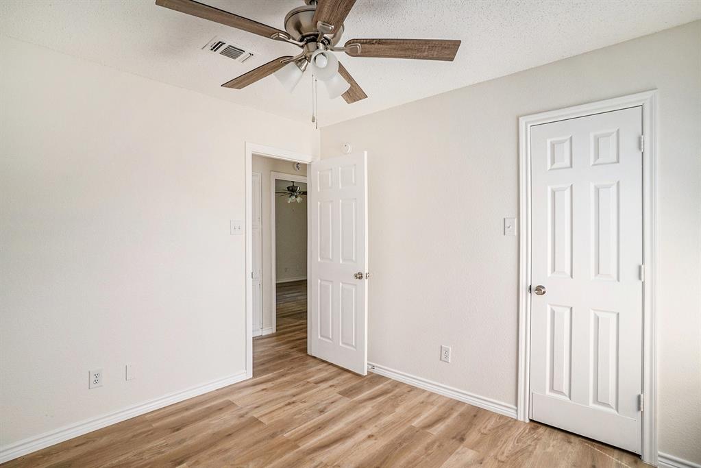 602 McAnear Street Cleburne, TX 76033 - Photo 18 of 27 an empty room with wooden floor closet and fan
