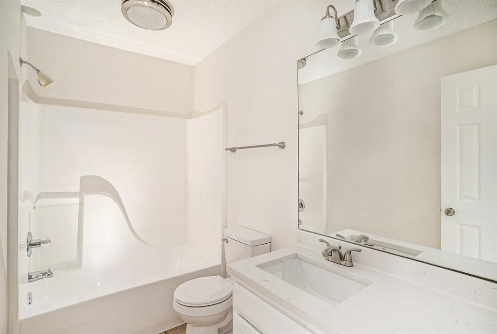 602 McAnear Street Cleburne, TX 76033 - Photo 22 of 27 a bathroom with a sink a toilet and shower