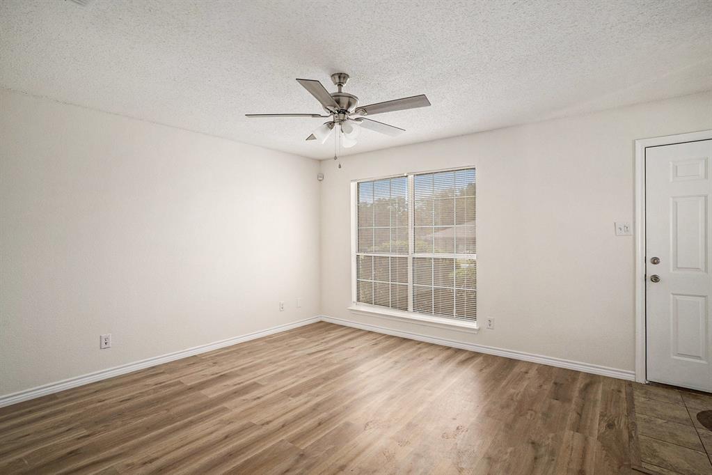 602 McAnear Street Cleburne, TX 76033 - Photo 5 of 27 wooden floor in an empty room with a window