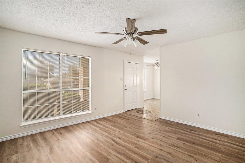 602 McAnear Street Cleburne, TX 76033 - Photo 7 of 27 an empty room with wooden floor cabinet and windows