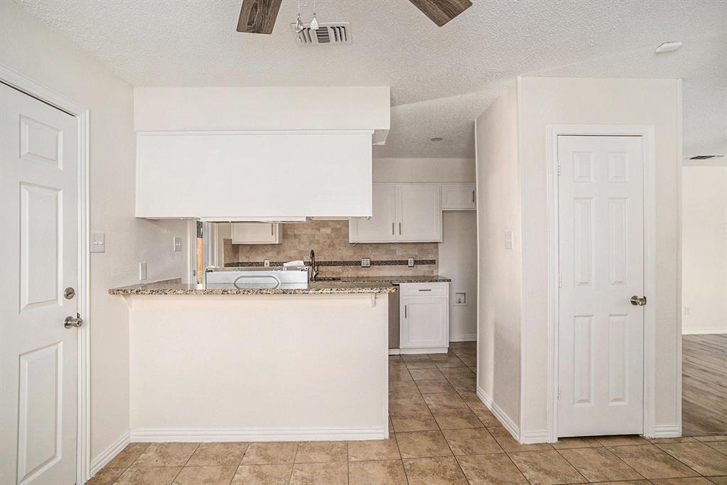 602 McAnear Street Cleburne, TX 76033 - Photo 10 of 27 a kitchen with kitchen island a sink a stove a refrigerator and a cabinets