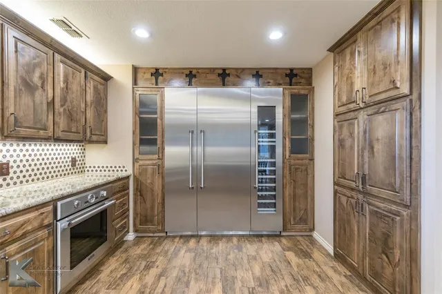 a kitchen with stainless steel appliances granite countertop a refrigerator and a stove