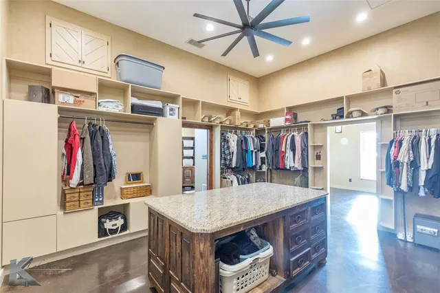 a view of a walk in closet with clothes and shoes