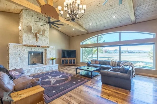 a living room with furniture large window and a fireplace