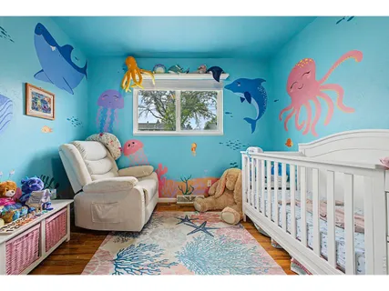 a living room with furniture and a baby crib