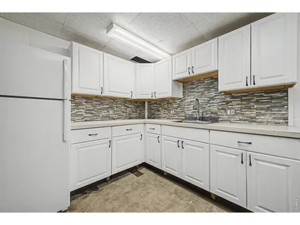a kitchen with white cabinets and white appliances