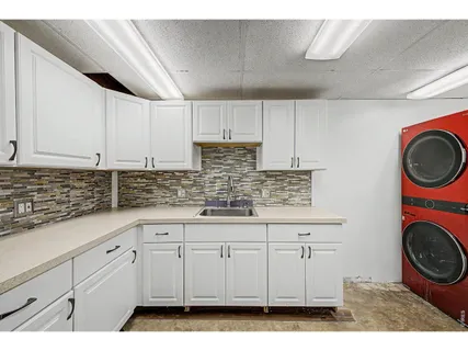 a kitchen with granite countertop a sink a stove and cabinets