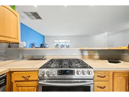 a kitchen with stove and cabinets