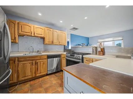 a kitchen with stainless steel appliances granite countertop a sink stove and refrigerator