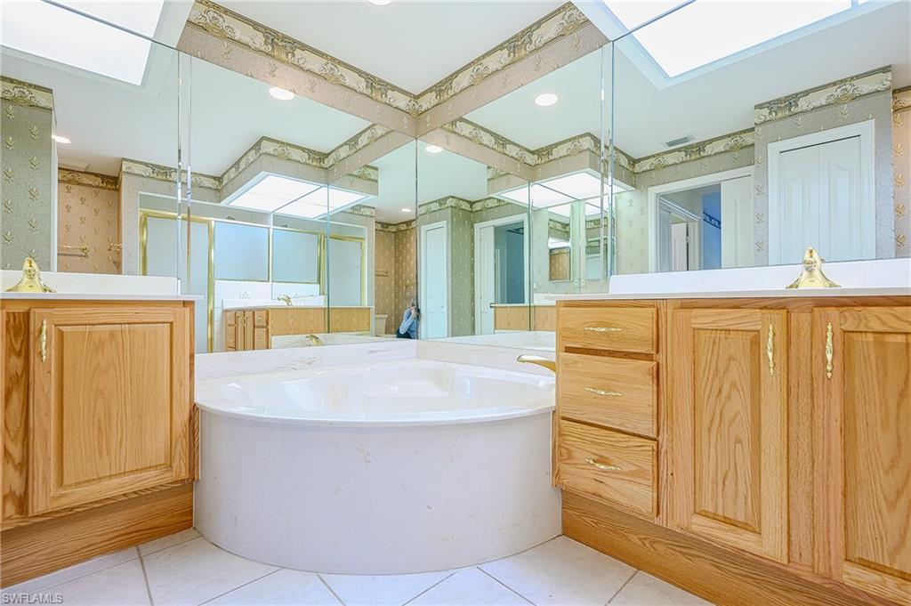5805 Grande Reserve Way, Unit 1102 Naples, FL 34110 - Photo 19 of 38 a large white tub sitting in a bathroom