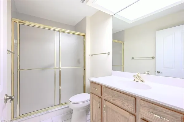 a bathroom with a granite countertop toilet a sink and a shower