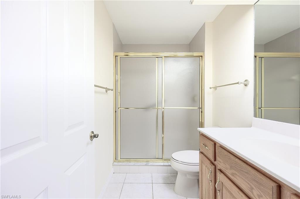 5805 Grande Reserve Way, Unit 1102 Naples, FL 34110 - Photo 22 of 38 a bathroom with a granite countertop toilet a sink and a shower