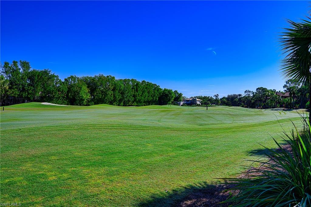5805 Grande Reserve Way, Unit 1102 Naples, FL 34110 - Photo 33 of 38 a view of a grassy field with trees in the background