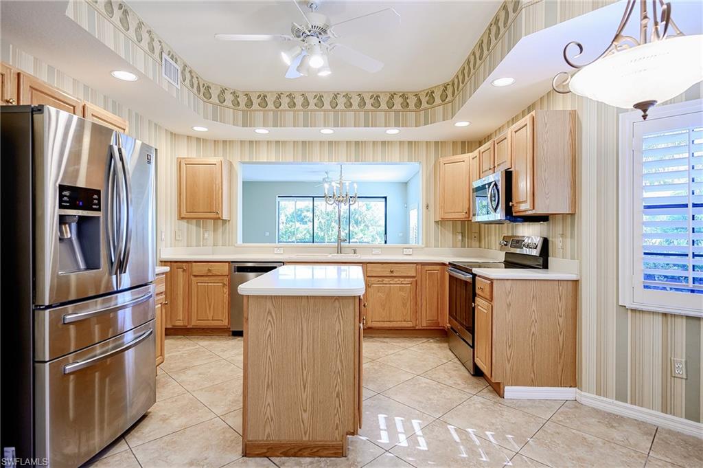 5805 Grande Reserve Way, Unit 1102 Naples, FL 34110 - Photo 8 of 38 a kitchen with a refrigerator and a sink